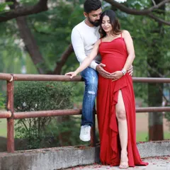 An outdoor maternity session offers a completely different vibe. We used the soft, natural light of a park in Navi Mumbai to capture this relaxed and romantic portrait. The vibrant red dress against the greenery creates a beautiful, timeless image.