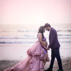 An intimate moment between an expecting couple on the beach. The soft focus on the waves and the gentle light create a dreamy, romantic atmosphere for this maternity portrait.