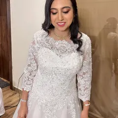 A happy, smiling portrait of the bride. Her makeup is subtle and fresh, with a focus on glowing skin and a soft pink lip, letting her natural beauty shine.