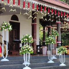 The entrance to this traditional home is lined with elegant floral stands. The arrangements of white and pink roses create a welcoming path for guests, showcasing our commitment to quality and detail at every step.