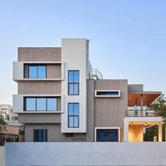 This view highlights the home's multi-level design and cubist forms. We used a combination of smooth white, textured grey, and vertically grooved panels to create a visually dynamic facade that changes with the light throughout the day.