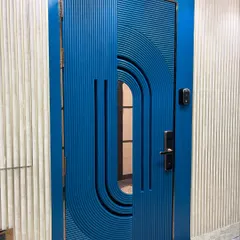 A statement main door with a bold blue PU finish and intricate fluted detailing. This custom safety door combines modern artistry with robust security, creating an unforgettable first impression for your home.