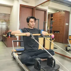 A male client works on the Reformer, demonstrating that Pilates is a highly effective workout for men seeking to build core strength, improve flexibility, and prevent injuries.