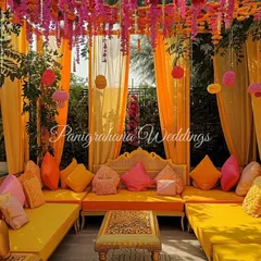 A cozy and colorful Mehendi seating area. We used bright orange and pink custom cushions, along with a ceiling of marigold strings, to create a traditional yet chic lounge space.