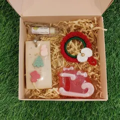 Another view of a beautifully packed Christmas gift box, showcasing a crochet wreath and other curated goodies, ready to be sent to a loved one.