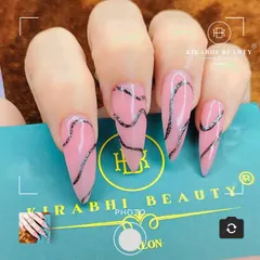 A trendy and abstract design with long, stiletto-shaped extensions. I used a sheer pink base and added wavy, textured silver-black lines for a modern artistic feel.