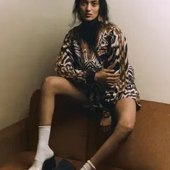 An unconventional and high-fashion shot. The unique styling with socks and platform heels, combined with the model's elongated pose, creates a memorable and editorial-worthy image.