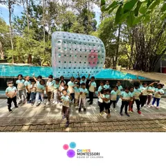 A group photo of our happy explorers at Discovery Village, with a giant zorb ball in the background promising more fun to come.