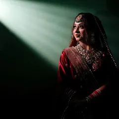 I love playing with light to create something truly magical. This dramatic bridal portrait uses a single beam of light to highlight the bride's anticipation and elegance just moments before her ceremony.