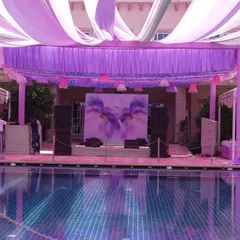 The stage, set against the pool, featured a beautiful watercolor-style floral backdrop. The entire setup, with its pastel drapes and reflections, created a truly magical atmosphere for the performances.