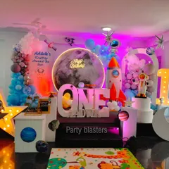 A first trip around the sun with our out-of-this-world space theme. This design includes a large moon backdrop with a neon "Happy Birthday" sign, custom astronaut and rocket ship props, and planetary details to create an immersive galactic adventure for a first birthday.