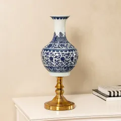 This blue pottery vase is a perfect example of the timeless craftsmanship I look for. The deep cobalt blue and intricate floral patterns are hand-painted, set on a modern brass stand to blend traditional art with contemporary design. It's a statement piece for any console or side table.