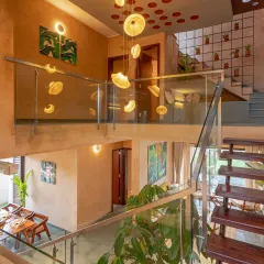 This double-height atrium in the Terravana Villa is designed to feel expansive and elegant. The custom light fixture, crafted from banana leaves, cascades down, drawing the eye upward and highlighting the vertical space. The entire composition is a carefully articulated play of volume, light, and natural texture.