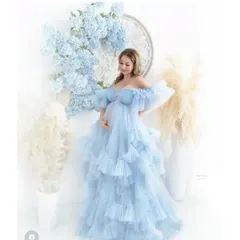 Imagine your photoshoot in this dreamy, sky-blue ruffled gown. The off-the-shoulder design and layers of soft tulle create a romantic, ethereal look, perfect for celebrating your pregnancy.