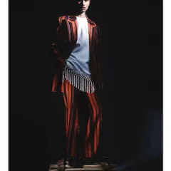 The model stands on a wooden pallet, illuminated by a single, harsh light source that casts deep shadows. This image from the 'Silhouette' series showcases a raw, industrial edge within a high-fashion context.