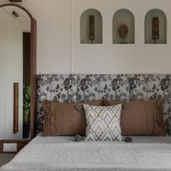 Your bedroom should be your personal sanctuary. We designed this space with a focus on tranquility, using a custom-printed headboard, earthy tones, and unique arched wall niches for a touch of personality and calm.