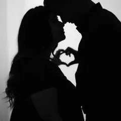 Sometimes the most powerful moments are the quietest. This artistic silhouette shot captures the intimate connection between expecting parents, with their hands forming a heart in the background, symbolizing the love that started it all.