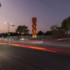 The Urban Twist sculpture at a busy Ahmedabad crossroads, seen here at dusk. This project showcases our approach to modern placemaking, using traditional brick in a dynamic spiral form to create a contemporary landmark that calms traffic and invites contemplation.