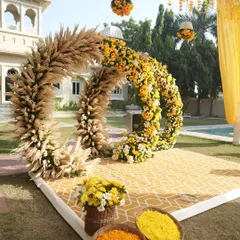 For this poolside Haldi, I designed a unique circular seating backdrop using pampas grass and sunflowers. This setup combines rustic textures with bright, happy florals for a modern and cheerful look.