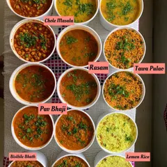 A beautiful spread of some of my popular dishes. This includes Chole Masala, Dal Fry, Rasam, Pav Bhaji, Tawa Pulao, and Lemon Rice, all bursting with homemade flavor.