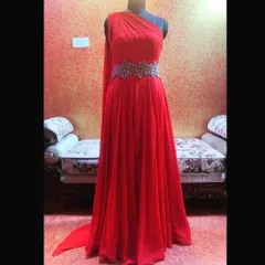 A show-stopping cocktail gown for a special occasion. This one-shoulder red gown features a flowing silhouette and a hand-embroidered belt made with semi-precious stones.