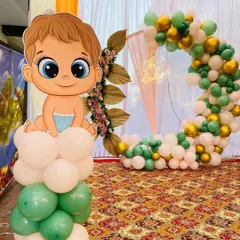 This 'Oh Baby' setup is perfect for a baby shower or welcome party. It features a large, cute baby character cutout on a balloon pillar, with a balloon ring arch and neon sign in the background.