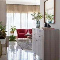 Designed for a professional golfer, this living room is a space to unwind. A calming pastel color scheme is energized by bold red accent chairs and a graphic striped rug, creating a perfect balance of style and comfort.
