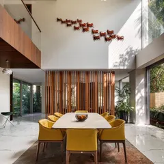 I design homes with spaces that breathe. This double-height dining area in the Kanasu residence connects vertically and opens horizontally to the outdoors, creating a sense of grandeur and seamless flow for family life.