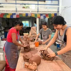 The large wooden tables are perfect for hand-building projects. Here, students are wedging clay, getting it ready for sculpting and shaping. It's a space for both individual work and collaborative energy.