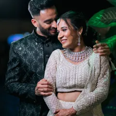 A chic and intimate portrait of a couple in contemporary evening wear. The dark, moody lighting adds a touch of sophistication to their engagement photos.