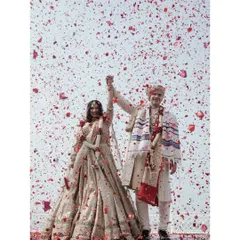 A magical moment as the couple is showered with rose petals after their beach ceremony in Goa. This is pure celebration.