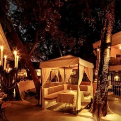 The restaurant at night, with candelabras and soft lighting creating a warm and inviting glow throughout the terrace.