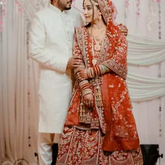 A beautiful couple portrait. My bride looks elegant and poised in her red embroidered lehenga, with makeup that enhances her features without overpowering them.