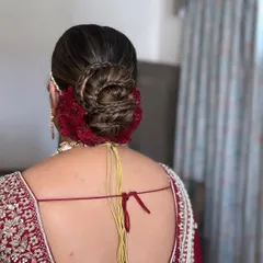For this bridal bun, I incorporated a braid into the twist for added texture and detail. The deep red cockscomb flowers provide a rich, velvety contrast, making this a truly unique wedding hairstyle.