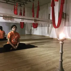 Practicing Trataka, or candle gazing meditation. This powerful yogic technique improves focus, calms the mind, and enhances concentration by fixing the gaze on a single point of light.
