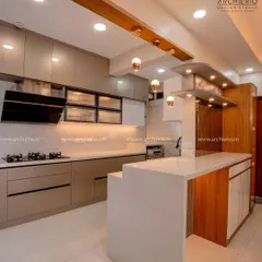 This open kitchen features a breakfast counter that doubles as extra prep space. The combination of wood and white finishes creates a warm and contemporary look.