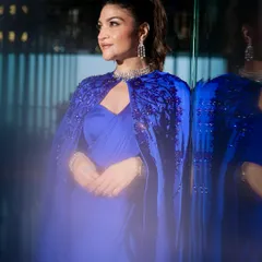 All eyes on this glamorous look. The client is wearing a stunning royal blue cape saree, and her makeup is equally dramatic, with bold eyes and a flawless base, perfect for a red-carpet-ready moment.