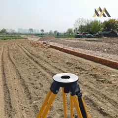 Every great project starts here, on the ground. This image shows the initial site survey and land preparation for a new farmhouse project, the very first step in turning a plot of land into a dream building.