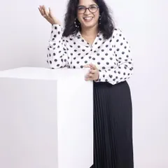Kala's journey shows that conscious styling is about understanding your body and personality, not just following trends. This classic polka-dot shirt and pleated skirt create a professional yet approachable look that is perfect for her personal brand.