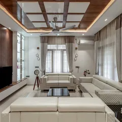 We believe a home's interior should be a sanctuary. This living room showcases our approach to interior design, using a calm color palette, luxurious textures, and a coffered ceiling to create a space that is both elegant and welcoming.
