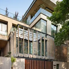 A daytime view of the Punjabi Bagh home shows how the architectural layers create depth and shadow. The design incorporates terraces and large windows to ensure that every level of the home feels connected to the outdoors.