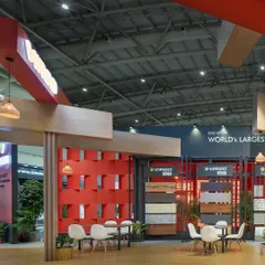 This 220 sq.m exhibition space for Virgo features a striking interplay of materials and volumes. A vibrant red lattice wall serves as a focal point, complemented by wood-clad structures and defined seating areas for visitor discussions.