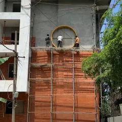 Our team carefully installs the circular frame for a facade emblem. This image captures the scale of the work and the collaborative effort required to execute detailed architectural features.