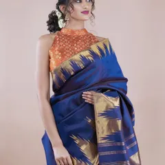 Here you can see how a traditional Kanjivaram silk saree can be styled for a contemporary look. The rich blue silk is paired with a modern halter-neck brocade blouse, creating a perfect fusion of classic and chic.