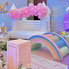 This themed soft play area included a white bouncy castle and a pastel rainbow climber, providing a safe and fun zone for toddlers that matched the party's aesthetic.