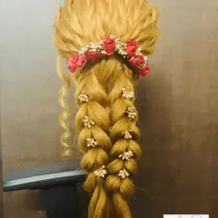 A demonstration of a voluminous, multi-strand braid decorated with floral accessories. This is a great way to see the structure of these intricate bridal hairstyles.