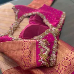 A pink blouse with a deep back neckline, adorned with playful peacock tassels on the sleeves.