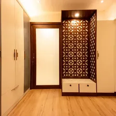 A stunning pooja unit from Bhavinee's home, featuring intricate dark wood *jaali* work. This piece serves as a beautiful and spiritual focal point in the room.