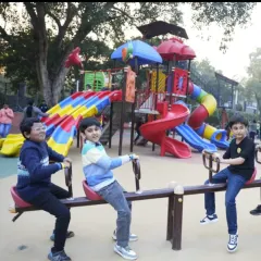 Classic playground fun on the seesaw with our large, multi-level slide structure in the background. It's a perfect spot for friends to play together.