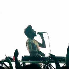 A powerful silhouette shot of me on the mic against a bright white screen. This captures the adrenaline rush I feel when I'm commanding the stage.